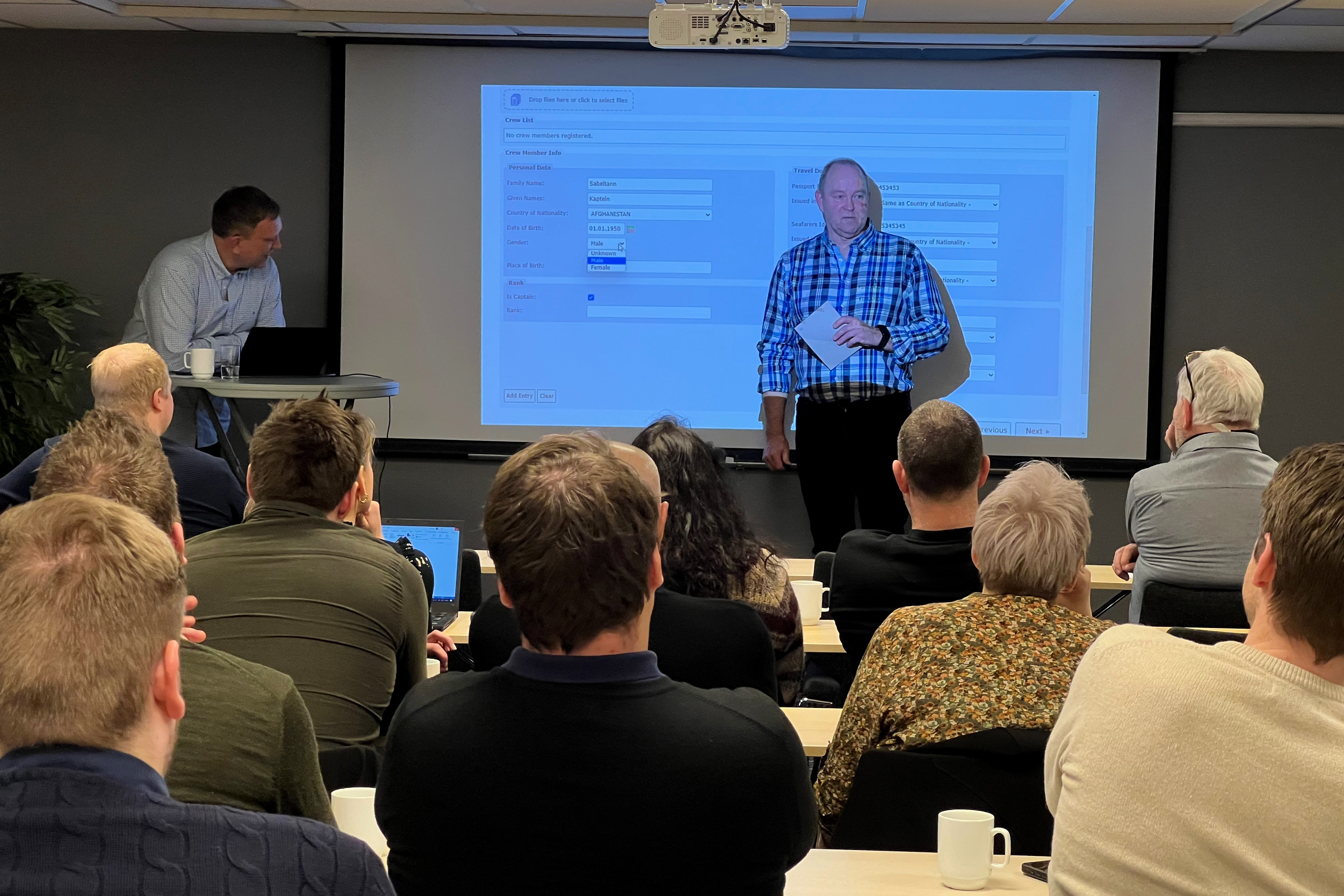 Representanter fra Kystverket viser systemet SafeSeaNet på storskjerm foran mange brukere i salen