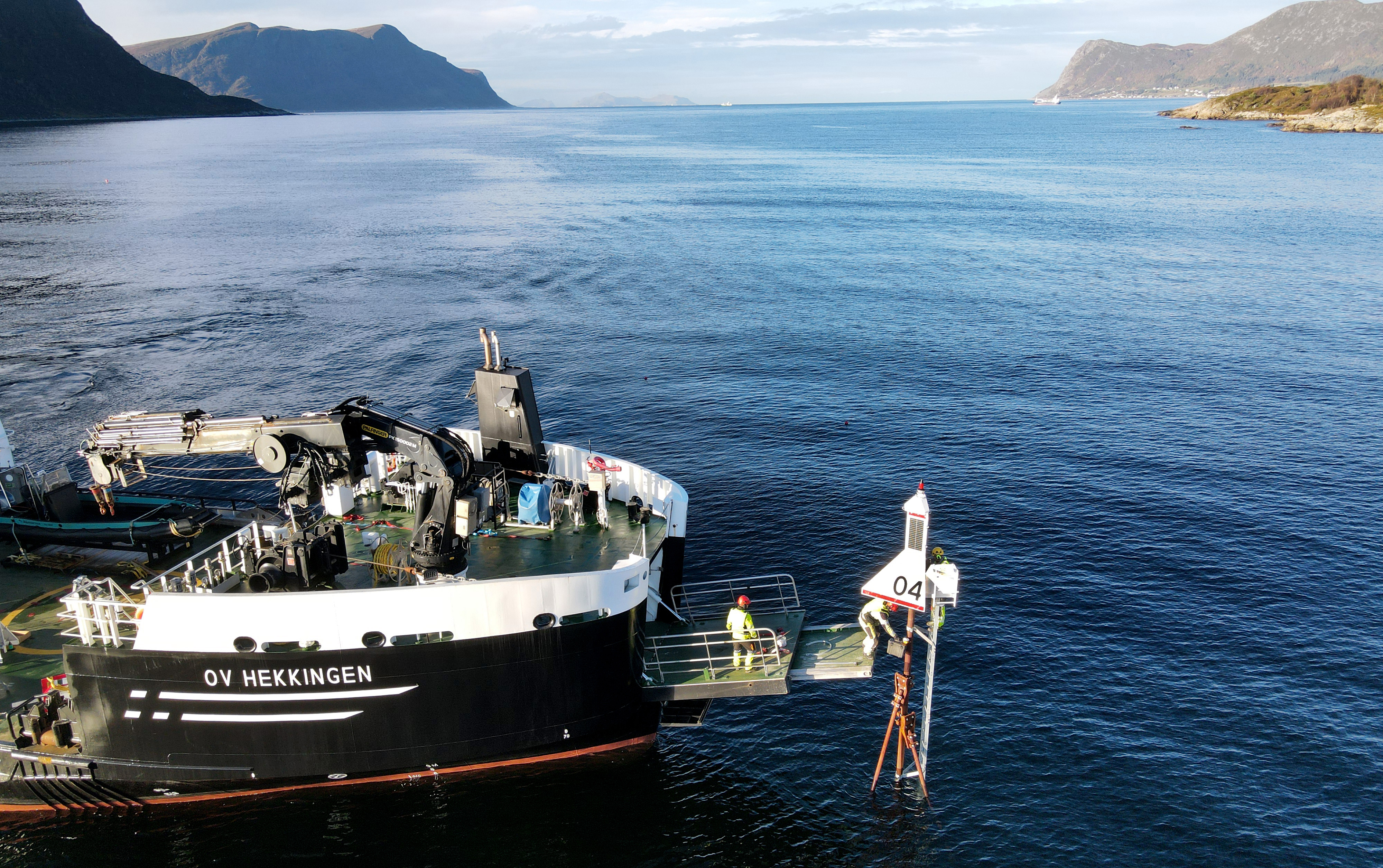 Båt som monterer sjømerke i innseilingen til Ålesund