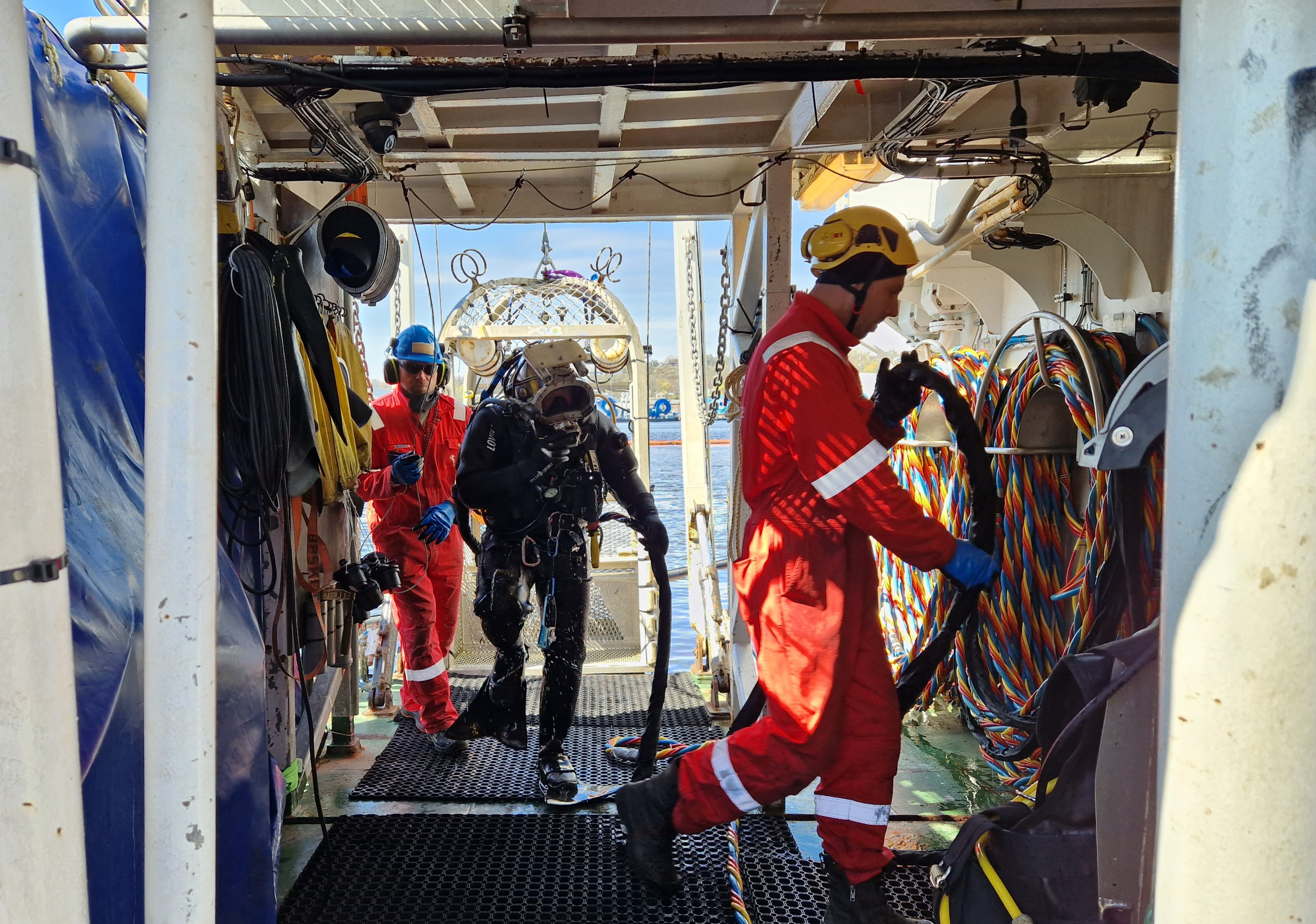 Dykker kommer opp av vannet ombord i båt