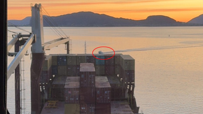 Liten båt kryssar framfor ein stor båt.