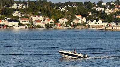 Stemningsbilde fra Arendal med liten båt på sjøen