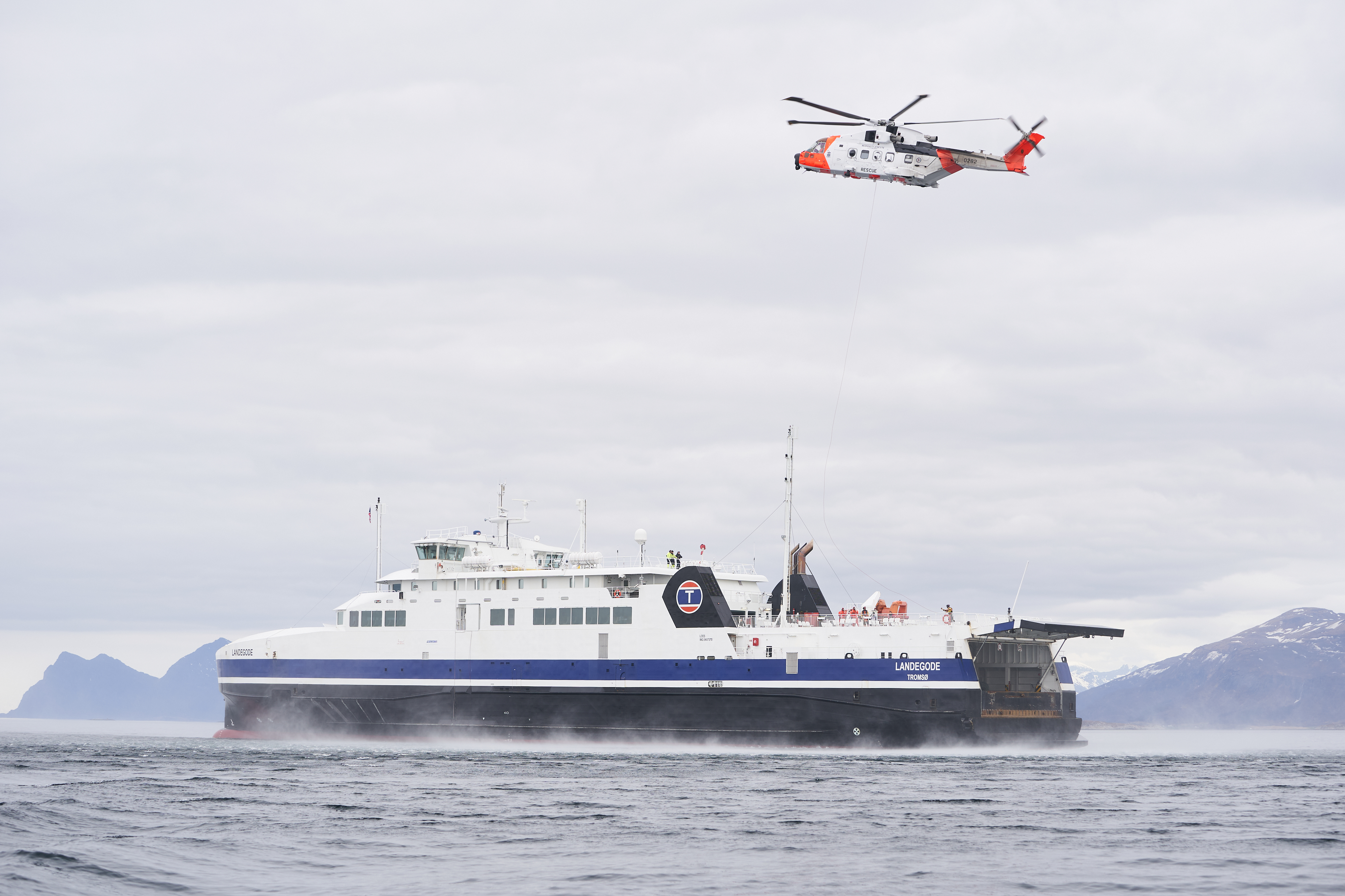 Redningshelikopter over fartøy til sjøs